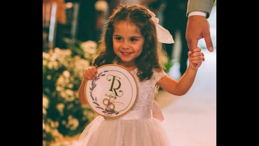 Criança segurando bastidor bordado personalizado em casamento